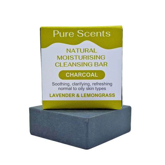 A charcoal goats milk soap bar with Lavender and lemongrass essential oils, displayed underneath another charcoal soap sitting on top with a olive green and white label.