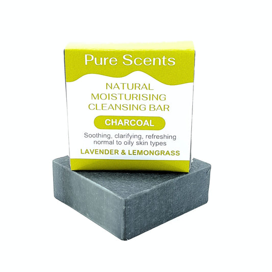 A charcoal goats milk soap bar with Lavender and lemongrass essential oils, displayed underneath another charcoal soap sitting on top with a olive green and white label.