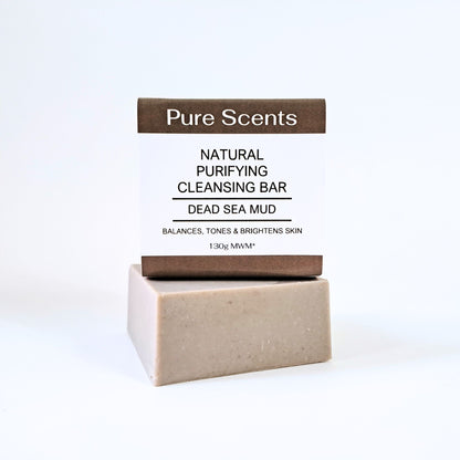 A bar of Dead Sea mud soap sitting on top of another bar of Dead Sea mud soap on a white background.