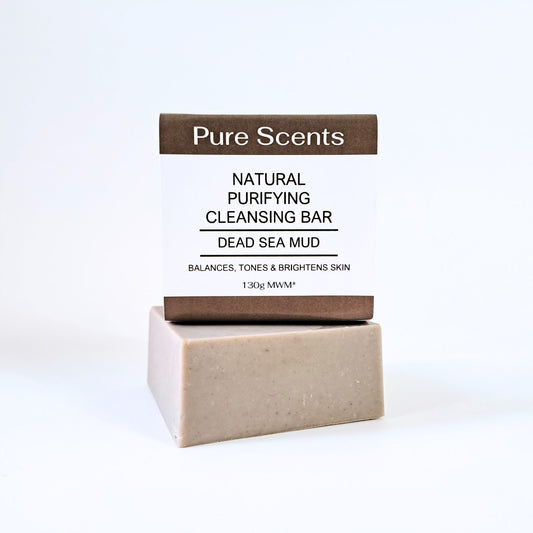 A bar of Dead Sea mud soap sitting on top of another bar of Dead Sea mud soap on a white background.